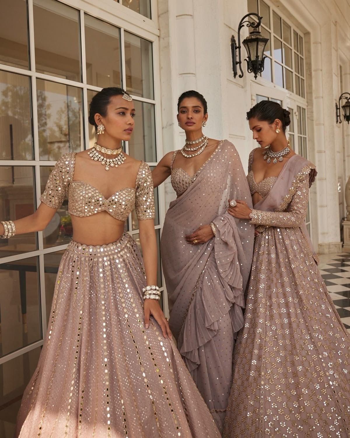 Three women wearing coordinated embellished wedding guest outfits